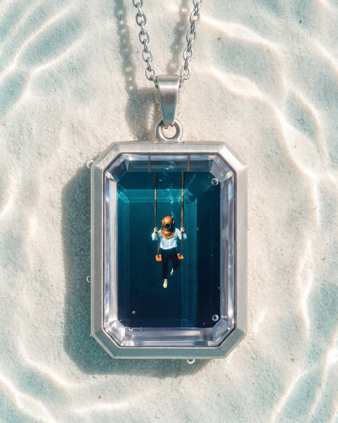 The Observer, the Amulet by Mirrors by Viulet, the Amulet large in its own world, silver, clear teal water