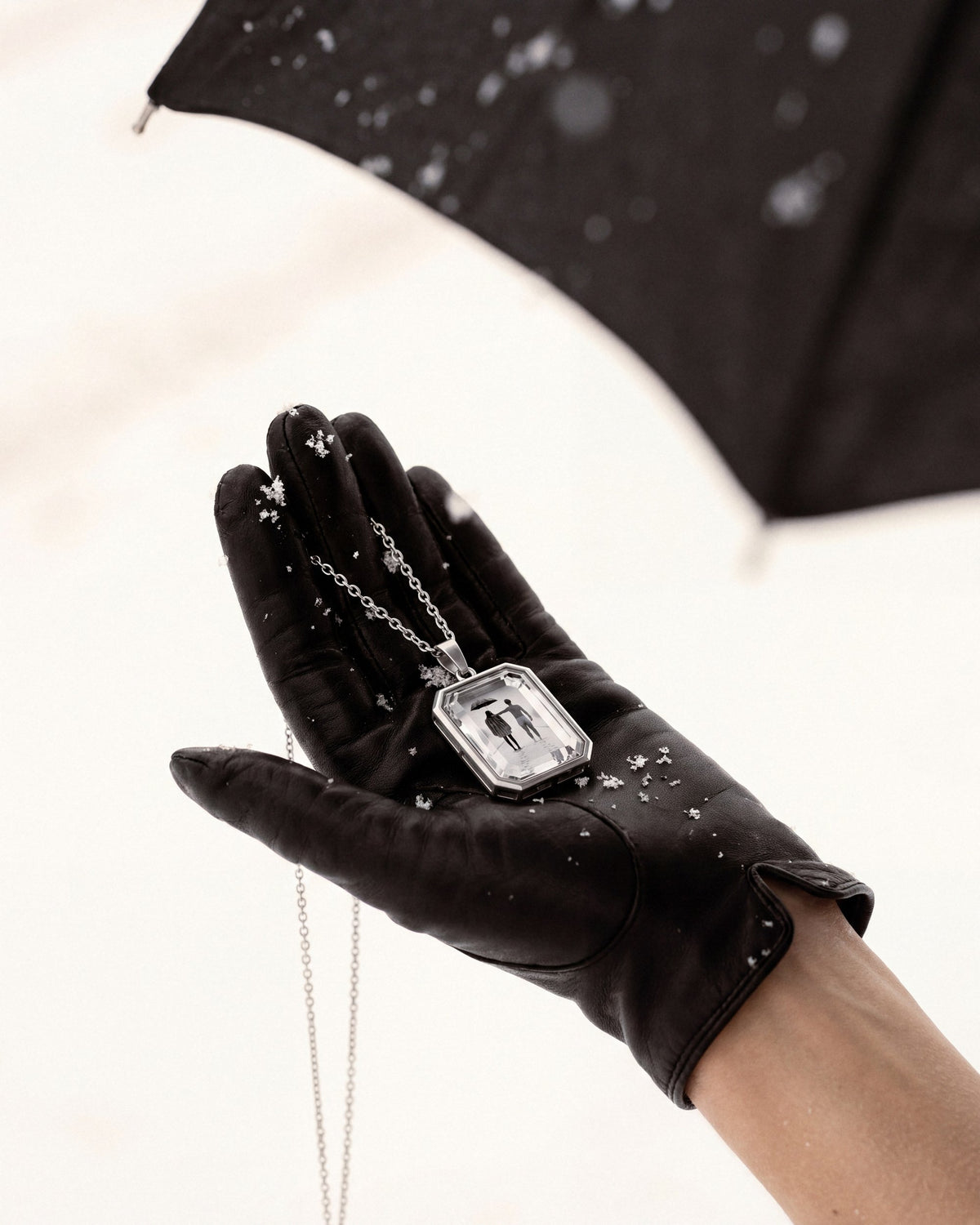 The Winter Between Us, the Amulet by Mirrors by Viulet, in her gloved hand